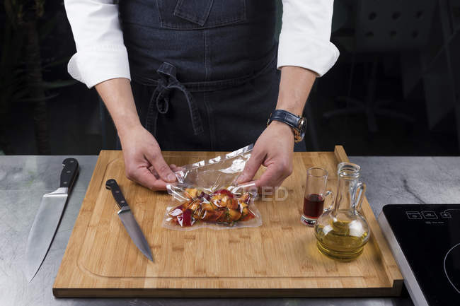 Cropped view of male chef marinating vegetables — Stock Photo