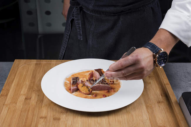 Nahaufnahme des Chefkochs Hand serviert Beilage — Stockfoto