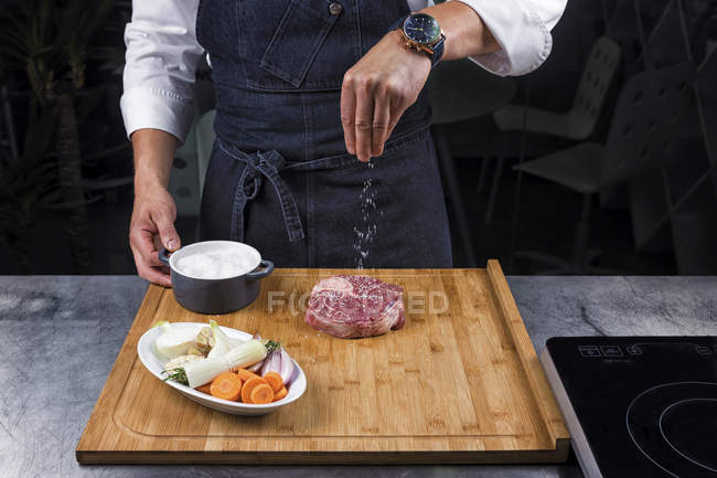Vista cortada do bife de salga do chef masculino — Fotografia de Stock