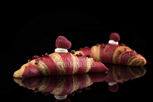 Croissants with striped pattern and fresh raspberries — Stock Photo