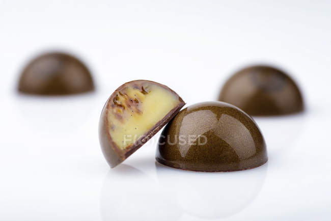 Bonbons au chocolat avec remplissage de caramel sur fond blanc — Photo de stock
