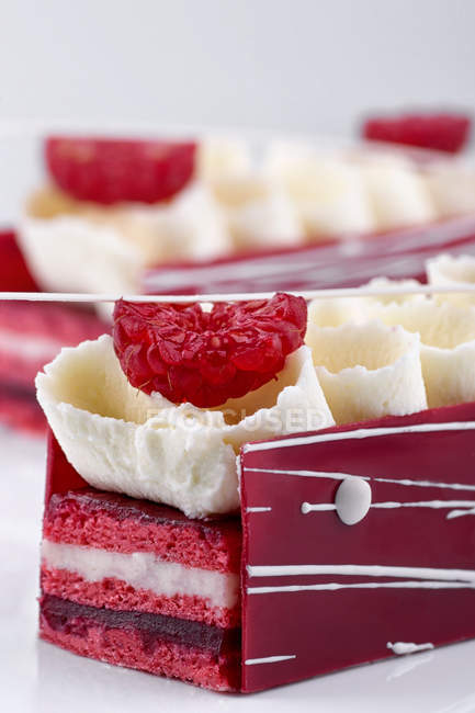 Pink cakes with cream and fresh raspberries — Stock Photo