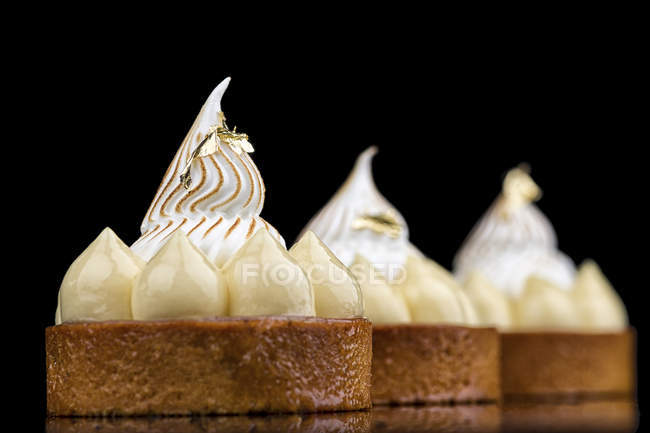 Round cakes with cream decoration on black background — Stock Photo