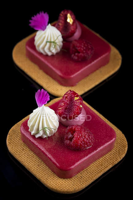 Gâteaux avec glaçure rose et framboises fraîches — Photo de stock