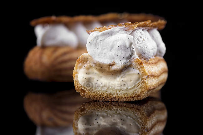 Close-up view of eclairs with cream filling and decoration — Stock Photo