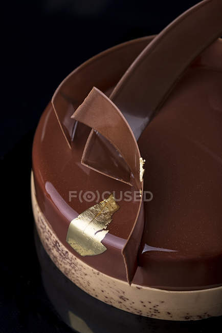 Vista de cerca de pastel de chocolate sobre fondo negro - foto de stock
