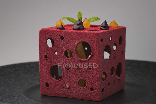 Торт в форме куба с отверстиями, заполненными свежими фруктами — стоковое фото