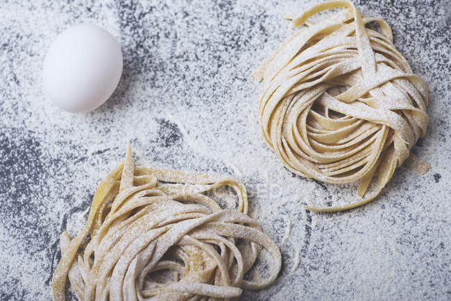 Hausgemachte Pasta auf Küchentisch mit Ei — Stockfoto