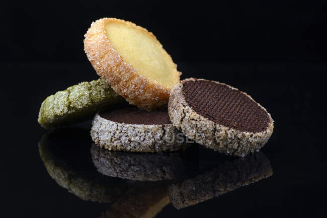 Varias galletas con glaseado de azúcar sobre fondo negro - foto de stock