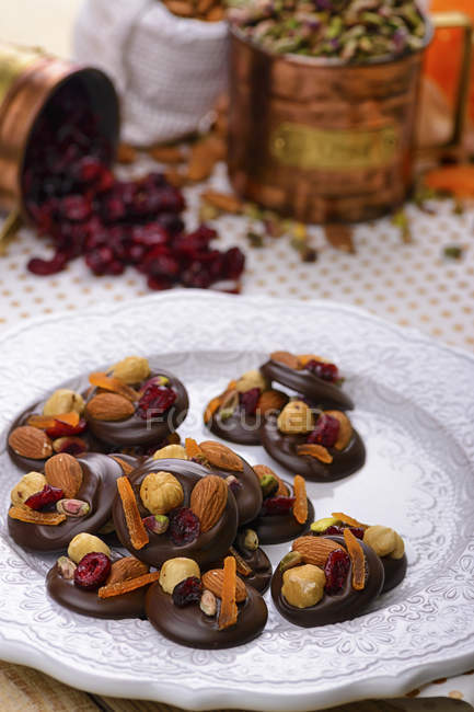 Chocolate candies decorated with nuts and dried fruits — Stock Photo