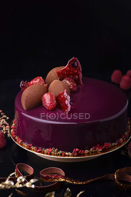 Pastel de chocolate con esmalte púrpura y bayas frescas - foto de stock