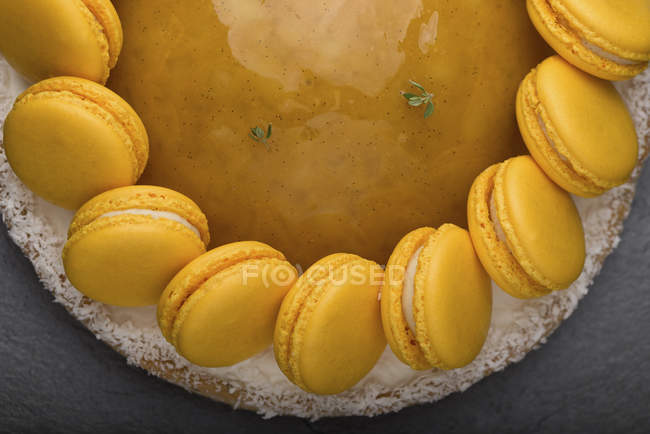 Nahaufnahme von Kuchen mit gelber Marmelade und Macarons-Dekoration — Stockfoto
