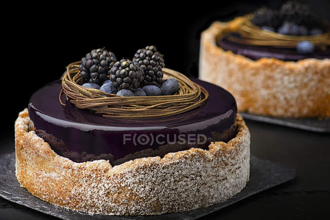 Cakes with purple glaze and fresh berries — Stock Photo