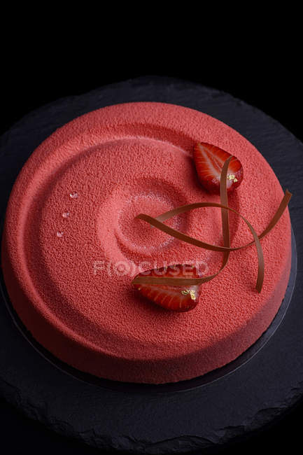 Gâteau avec glaçage rouge et décoration fraise fraîche — Photo de stock