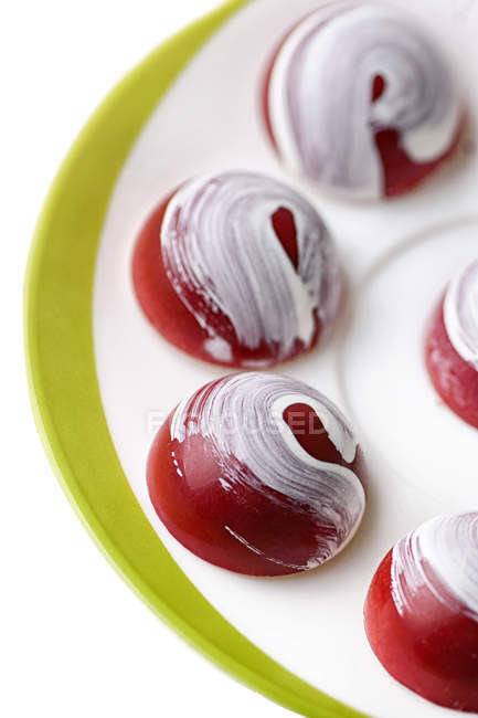 Close-up of red chocolate candies with white glaze painting — Stock Photo
