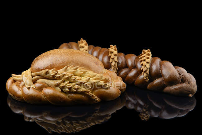 Braided bread loaves with wheat ears decoration — Stock Photo