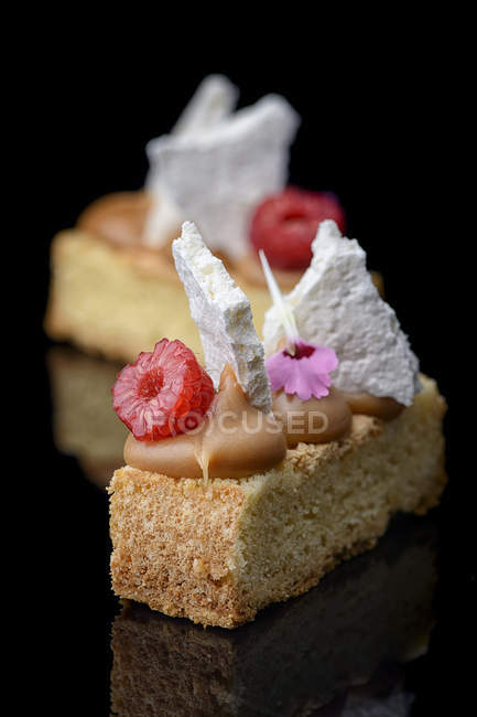 Cakes with caramel, meringues and raspberries decoration — Stock Photo