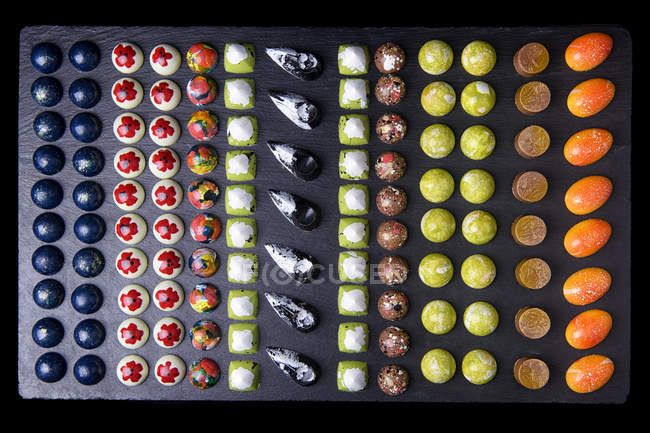 Divers bonbons au chocolat avec glaçure colorée, vue de dessus — Photo de stock