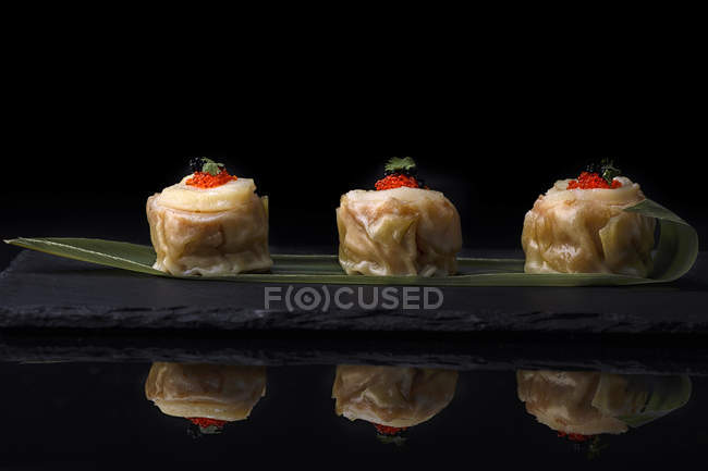 Dumplings décorés de caviar servi sur feuille — Photo de stock
