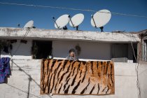 Женщина с тигровой напечатанной клеткой на балконе — стоковое фото