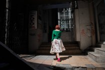 БЕЛГРАД, СЕРБИЯ - CIRCA MAY, 15: Вид сзади на рыжую женщину перед потрепанным входом в здание . — стоковое фото