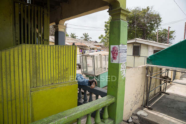 Ноги чоловік лежить на паркан біля будівлі — стокове фото