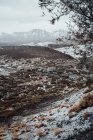 Valle herboso cubierto de nieve, cordillera de fondo - foto de stock