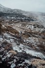 Травянистая долина, покрытая снегом, горный хребет на заднем плане — стоковое фото