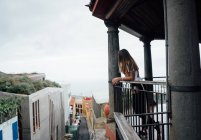 Молода жінка дивиться з балкона на оглядовий майданчик — стокове фото