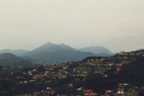 Idyllischer Blick auf die Stadt im Tal über neblige Hügel an bewölkten Tagen — Stockfoto