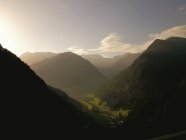Paisaje sereno de montañas brumosas y valle en día soleado - foto de stock