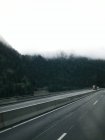 Vista para a estrada de tráfego no campo nebuloso — Fotografia de Stock