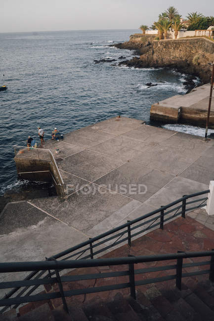 Pêcheurs pêchant au quai de béton de la ville — Photo de stock