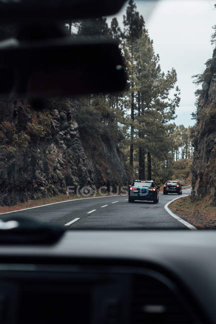 View through wind glass to cars riding at mountain road — Stock Photo