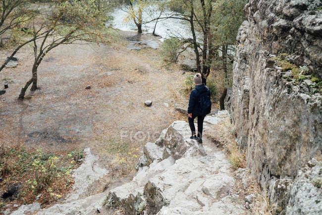 Rear view of person walking on boulder at countryside — Stock Photo