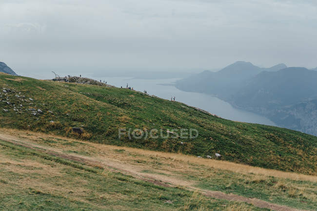 Спокойный ландшафт зеленого холма над туманной рекой — стоковое фото