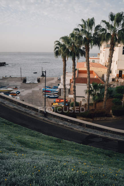 Порожня дорога, будівлі та човни на березі моря — стокове фото