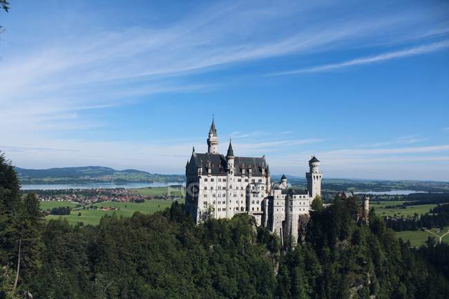 Замок на зеленому пагорбі над яскравим небом — стокове фото