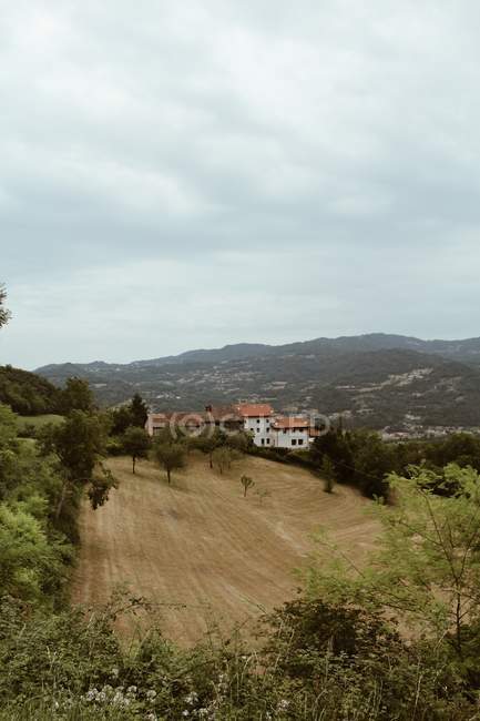 Aerial view of slope on background of valley town on cloudy day — Stock Photo
