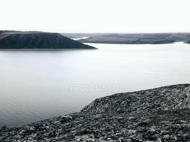 Paesaggio tranquillo della riva del fiume con sponde rocciose — Foto stock