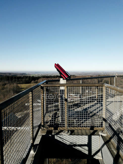 Telescopio rojo en la cubierta del cielo en el fondo de los campos de campo y cielo despejado - foto de stock