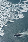 Aerial view of ice floes and swimming ship on water surface — Stock Photo