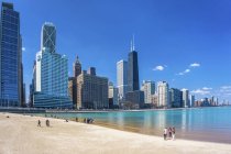 Люди, гуляющие по пляжу на переднем плане и городскому пейзажу Чикаго, Илинуа, США — стоковое фото