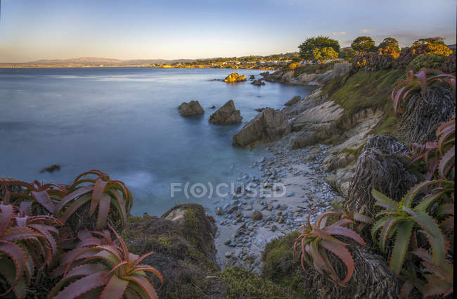 Vista panoramica della costa rocciosa con superficie dell'acqua in primo piano — Foto stock
