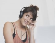 Young woman using headphones looking away — Stock Photo