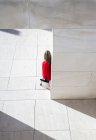 Blick von oben auf eine Frau im roten Mantel, die in der Stadt spaziert — Stockfoto