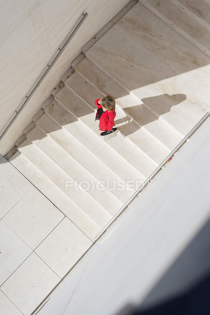 Vista aérea de la mujer adulta media caminando por las escaleras de la ciudad - foto de stock