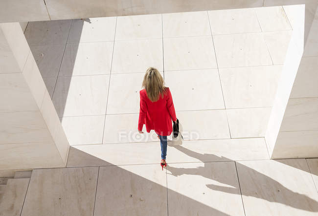 Visão aérea da mulher de casaco vermelho andando na cidade — Fotografia de Stock