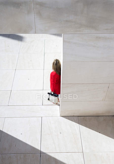 Vista aerea della donna in cappotto rosso che cammina in città — Foto stock