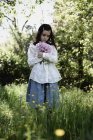 Girl holding bunch of pink peonies in countryside garden. — Stock Photo
